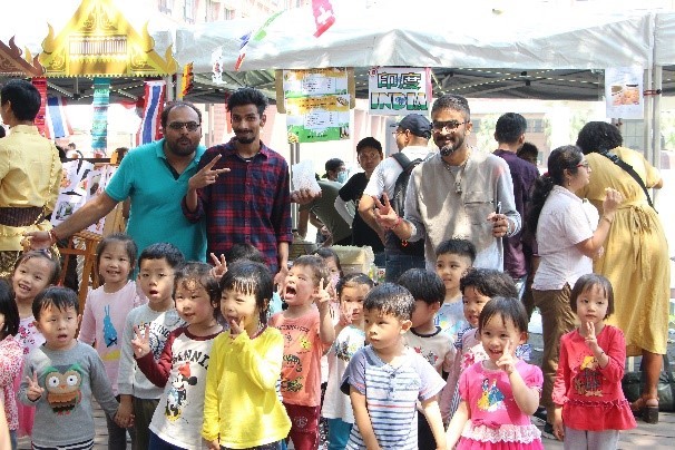 中山大學附屬幼兒園學生最愛與各國美食攤位的國際生互動。